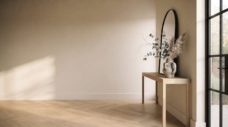 Elegant entryway with herringbone hardwood flooring, an oak console and an arched mirror